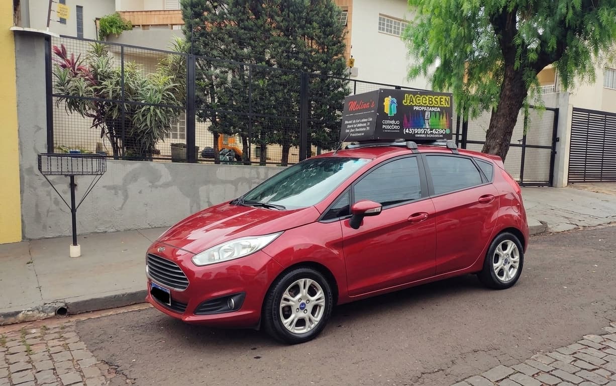Carro de som da Jacobsen Propaganda com caixa de alto-falantes no teto, em rua de Cornélio Procópio – PR